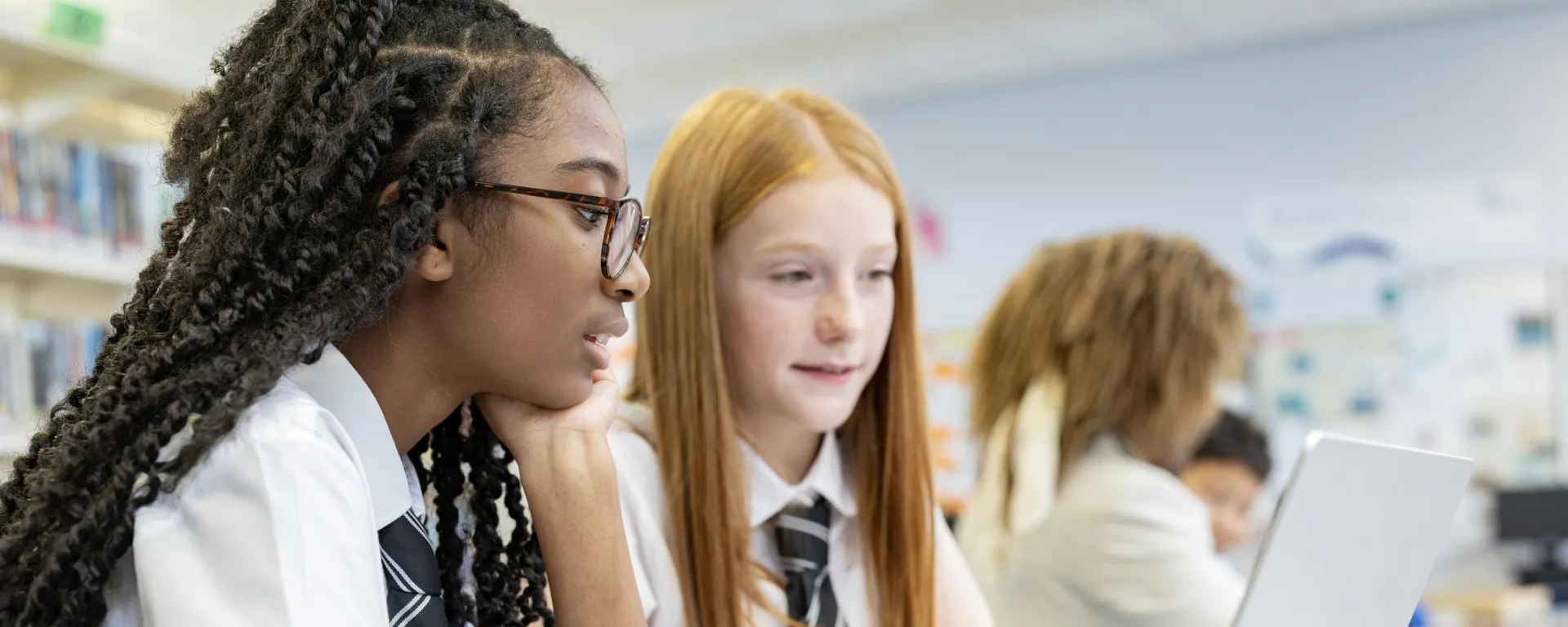 Two people discussing work at a desk.
